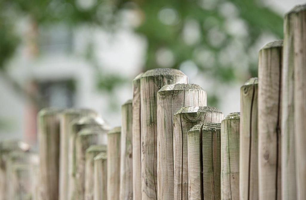 Kwalitatieve houten schutting in tuin die privacy en bescherming biedt