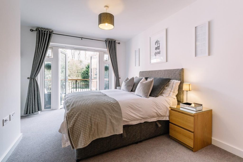 Gezellige slaapkamer met goed matras, verlichting en opbergruimte voor het opnieuw inrichten